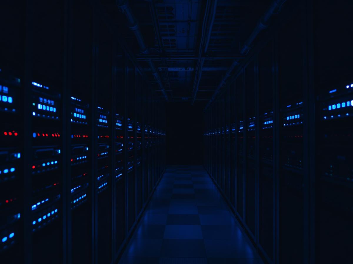 Dark data center aisle with backup storage arrays lit in blue